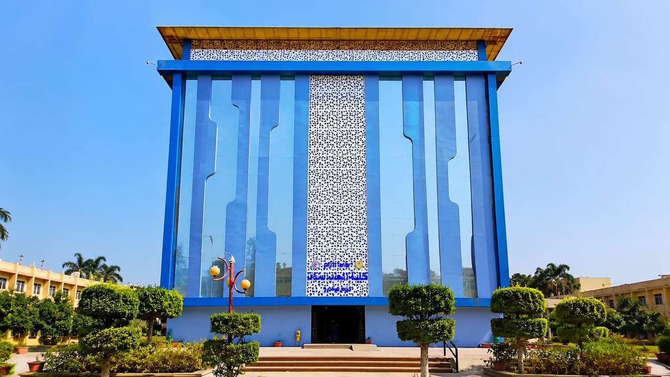 The blue-and-white facade of an Al-Azhar University Faculty of Medicine building in Nasr City, Cairo, with Arabic signage and a patterned mashrabiya-style band over the entrance