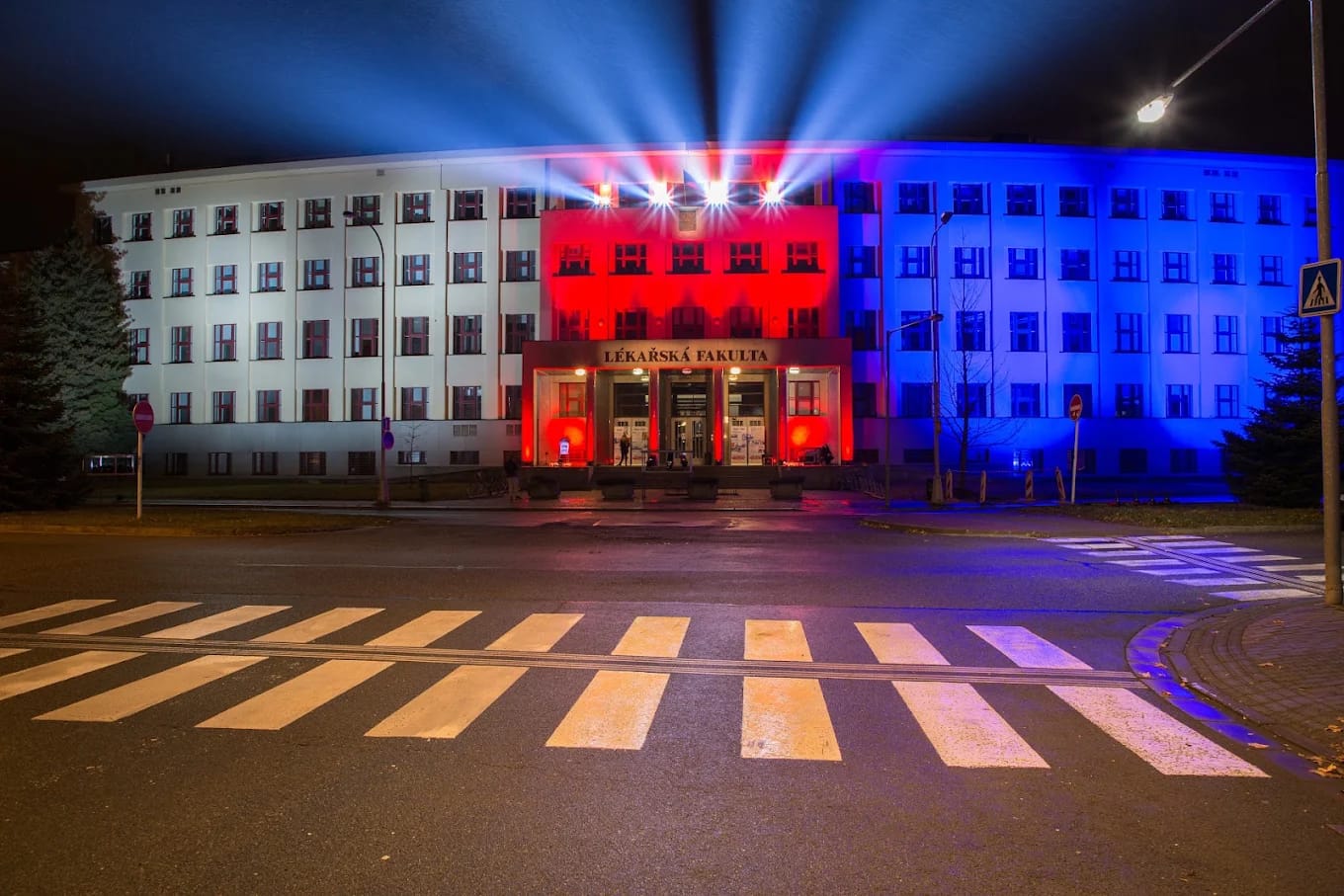 Faculty building illuminated in the Czech national colours at night