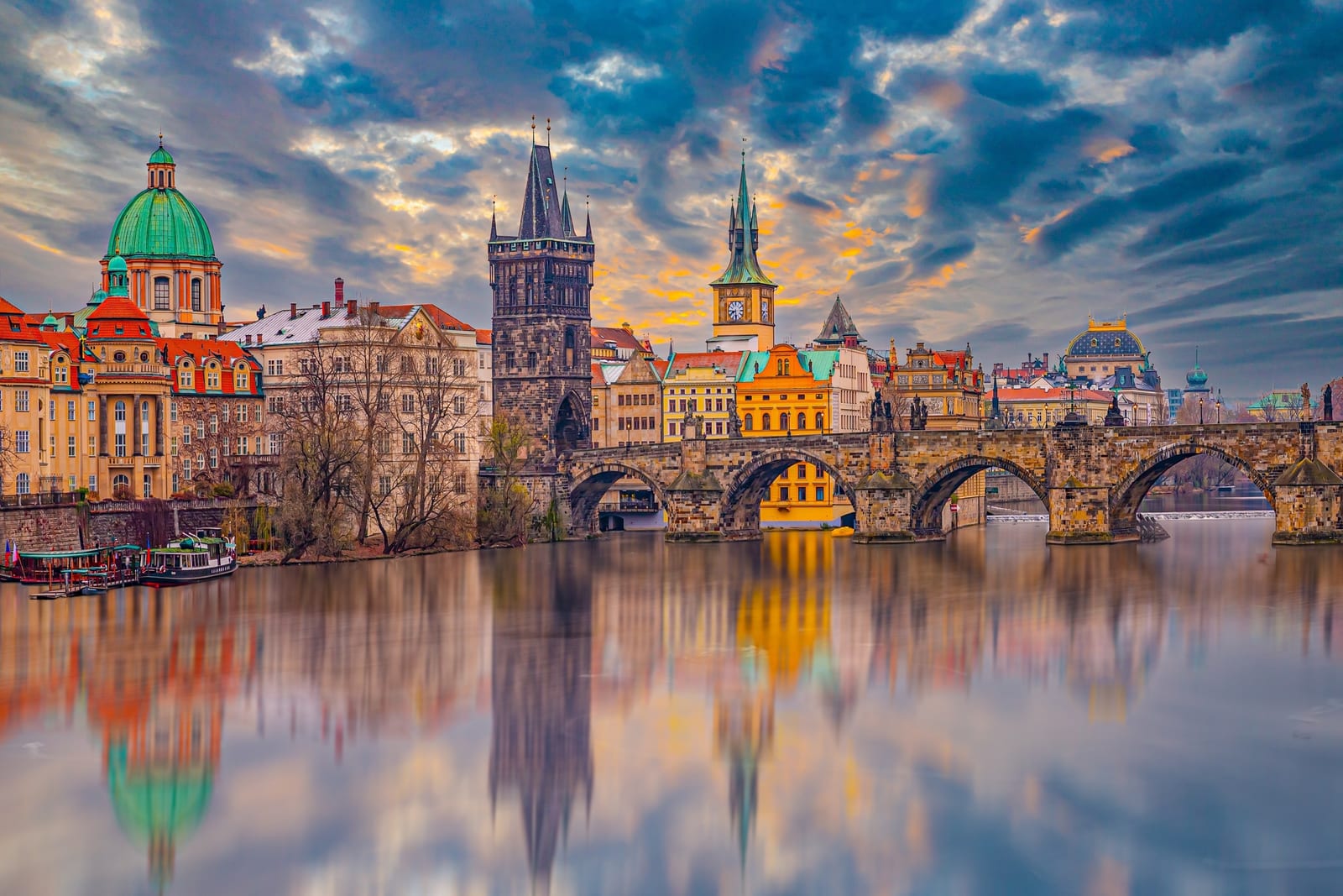 Charles Bridge and its towers reflected in the Vltava at dusk