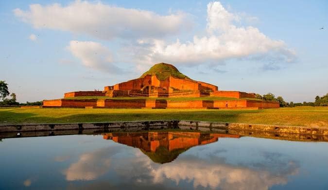 Somapura Mahavihara (Paharpur) Buddhist monastery ruins reflected in water at sunset, Bangladesh