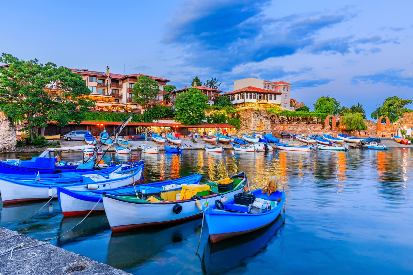Blue fishing boats in the harbour of Nessebar old town at dusk, Bulgaria
