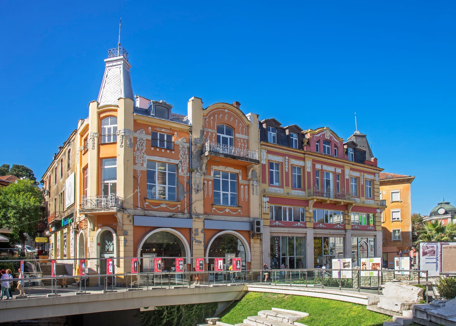 Ornate historic commercial building beside a river in a Bulgarian city