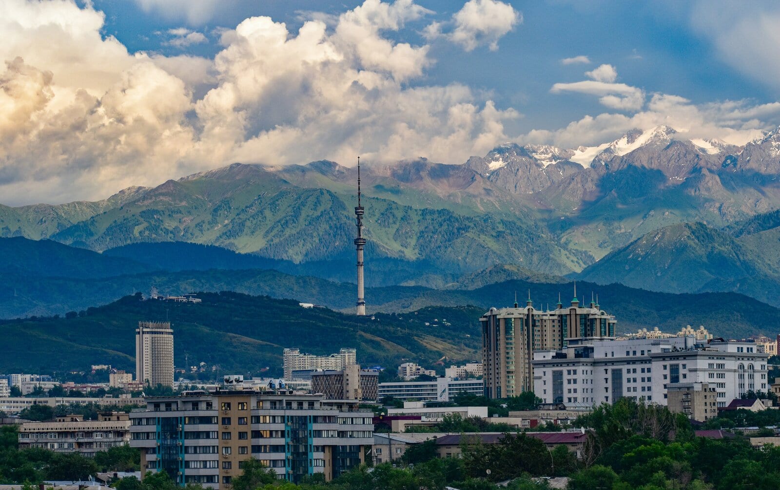 Snow-capped mountains above a lake and steppe landscape in Kazakhstan