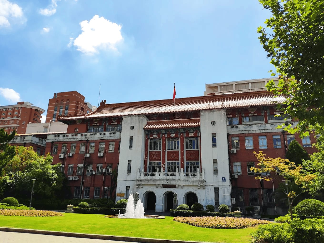 The historic red-brick main building of Fudan University Shanghai Medical College with a fountain in front