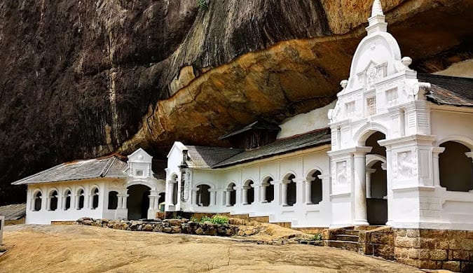 The white-walled Dambulla cave temple set against its rock overhang in Sri Lanka