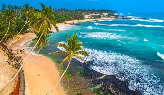 A palm-fringed golden beach on the south coast of Sri Lanka