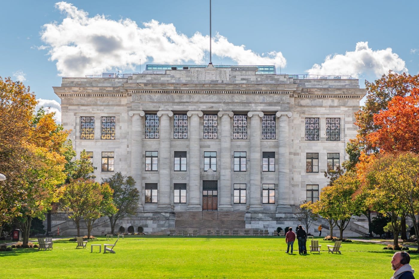 A Harvard Medical School building in autumn with students on the quadrangle lawn