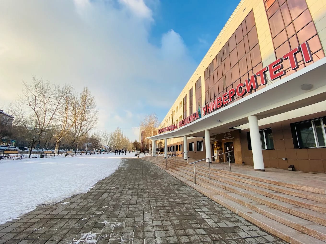 The modern entrance building of Karaganda Medical University in winter, with its Kazakh signage