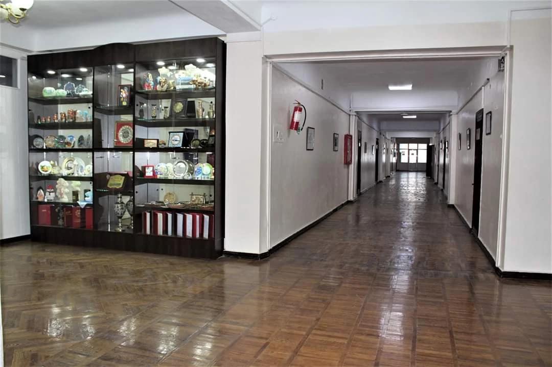 A corridor with historical display cases inside a Kyrgyz State Medical Academy building