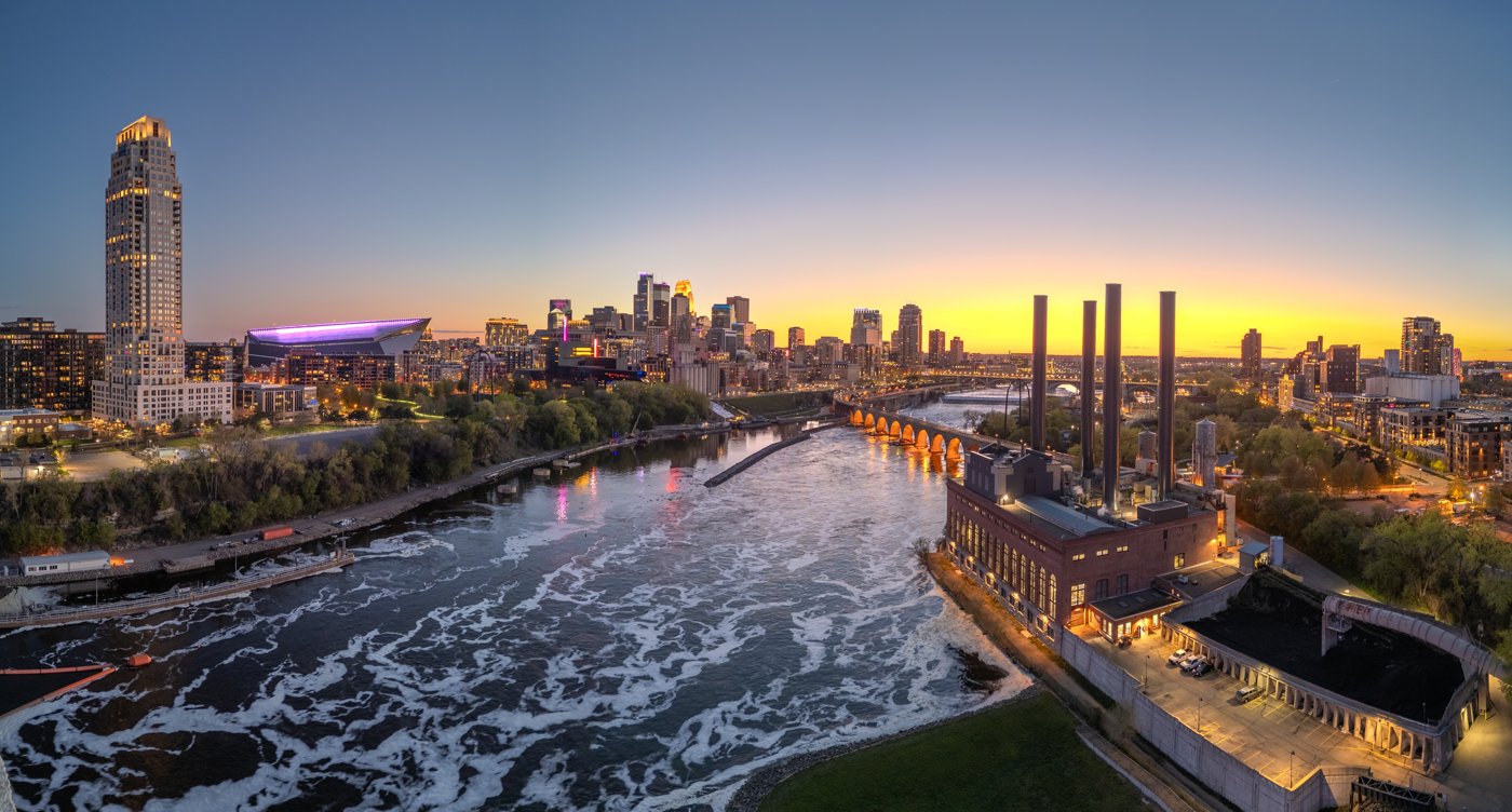 A Minnesota city skyline at sunset over the river