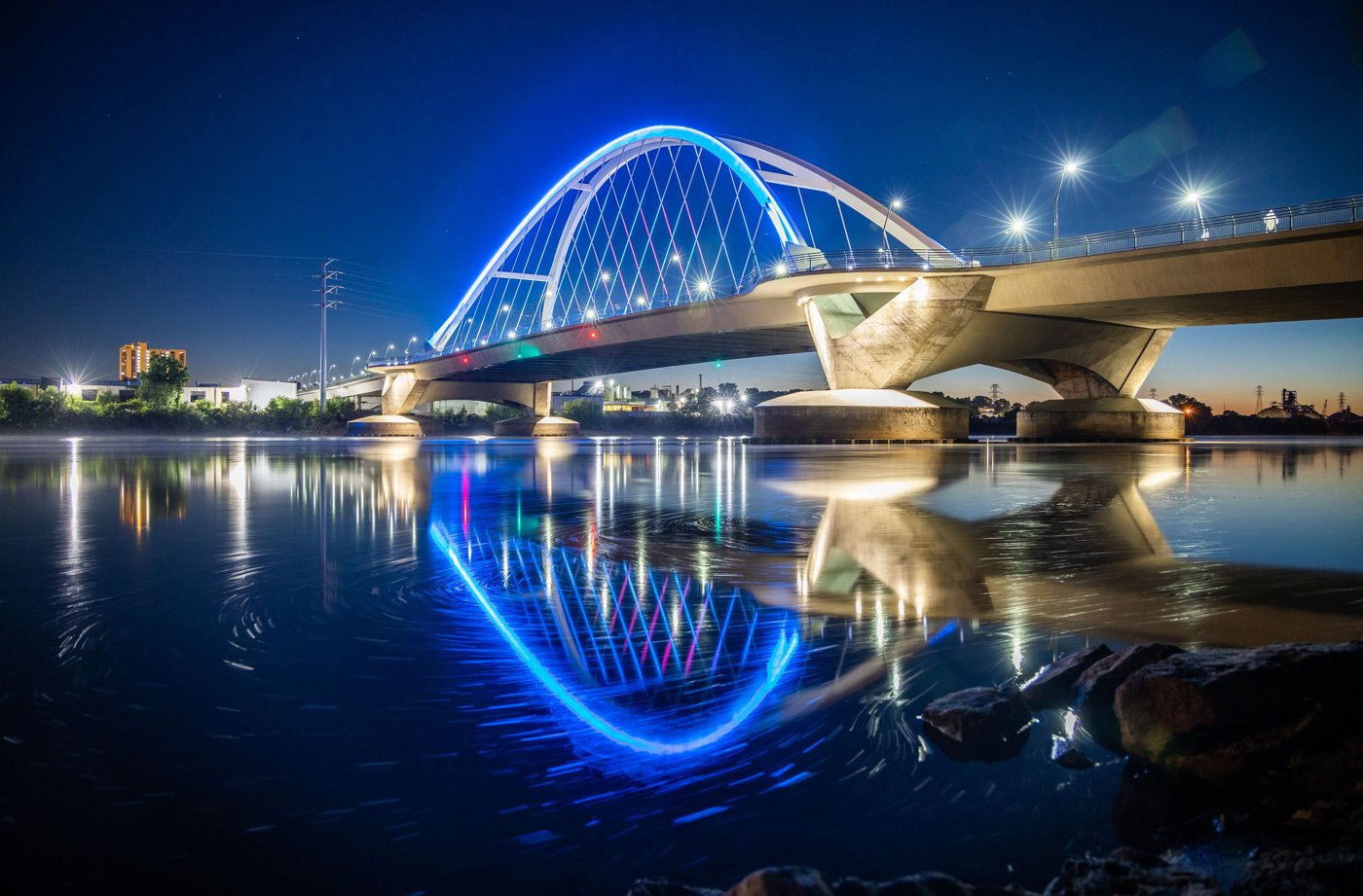 An illuminated arch bridge over a Minnesota river at night