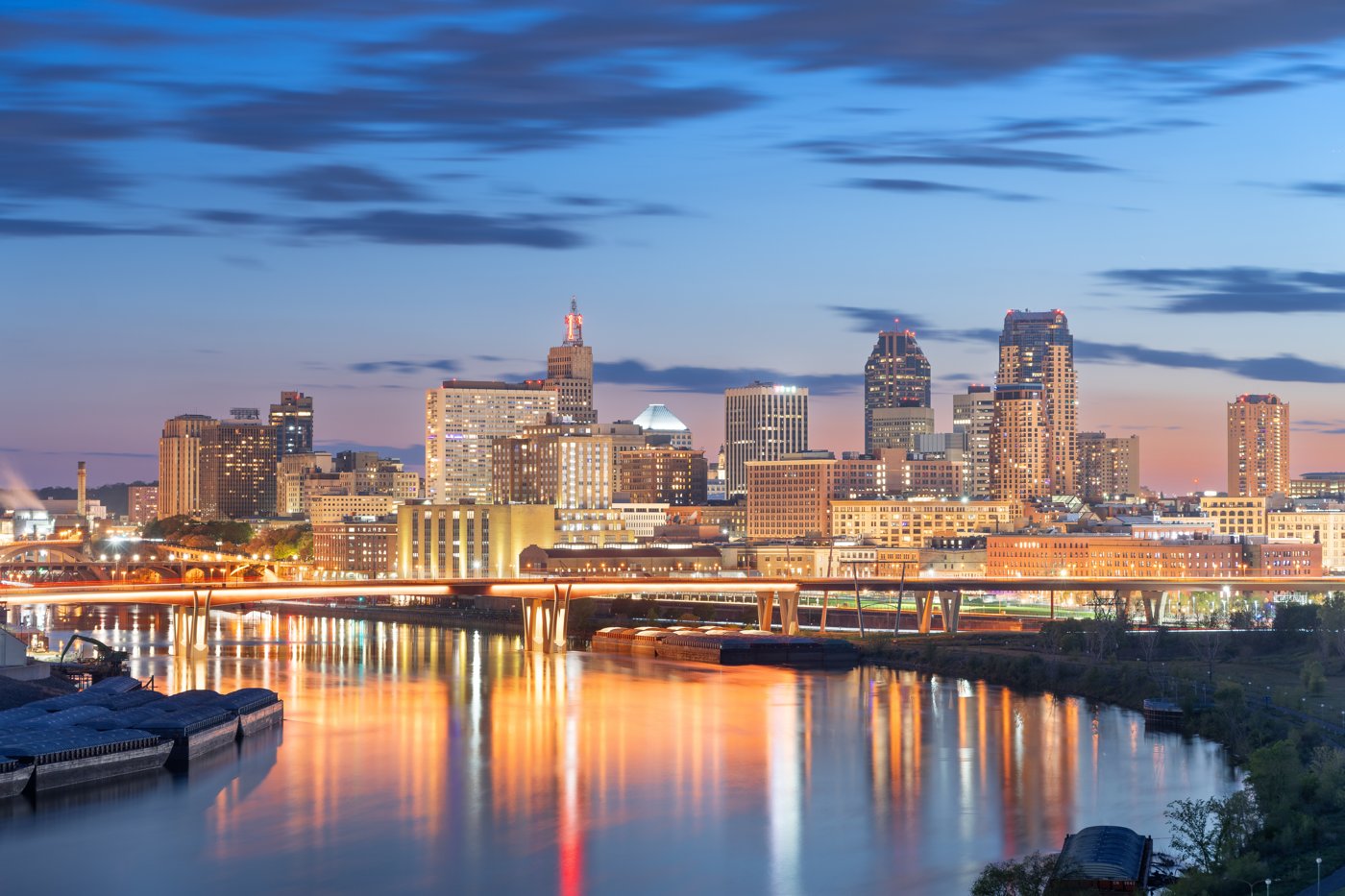 A Minnesota twin-cities skyline at dusk over the river