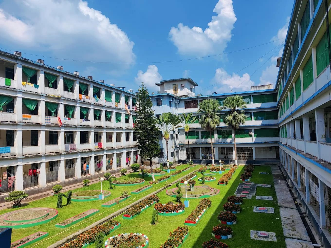 Green courtyard garden framed by the multi-storey academic and hostel blocks of Mymensingh Medical College
