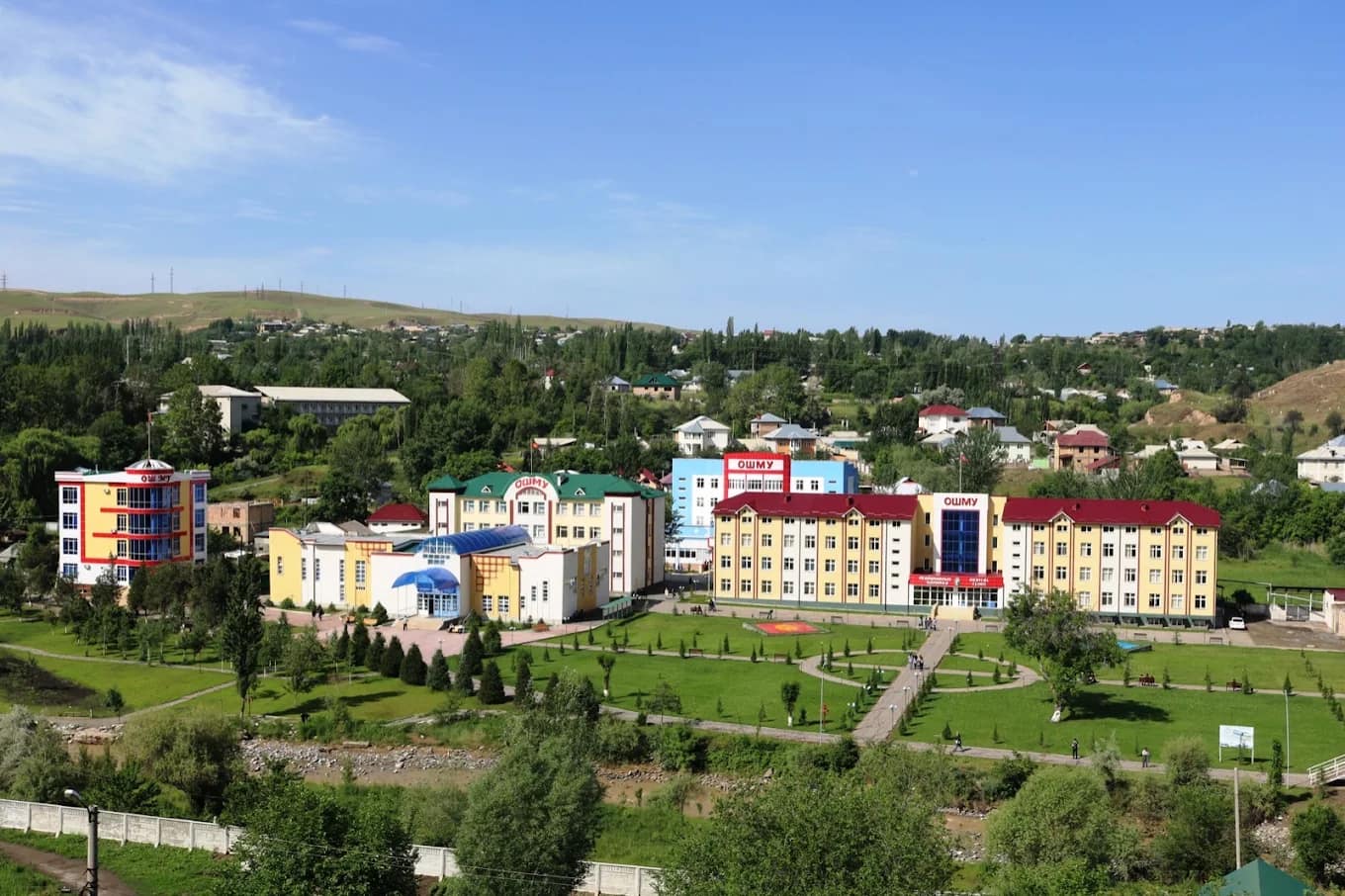 The main building of Osh State University with gardens and pathway
