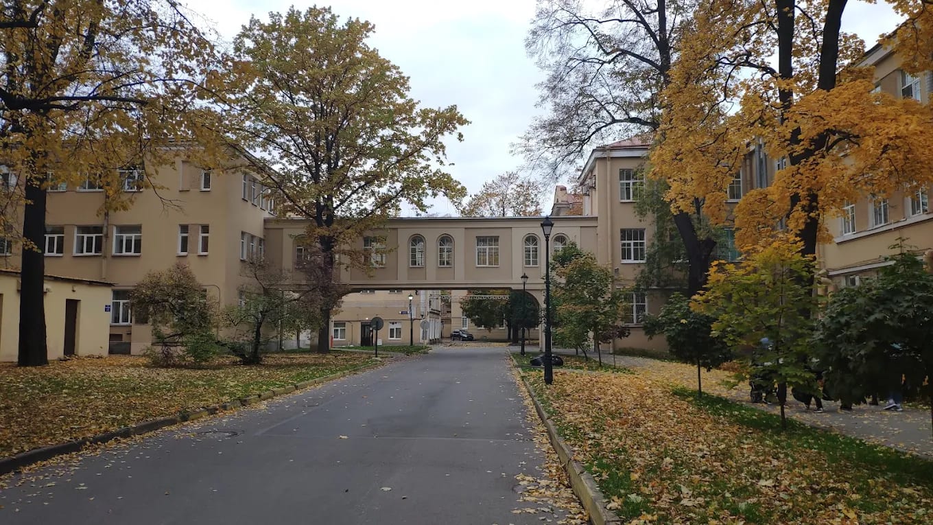 An autumn courtyard on the Pavlov University campus in St Petersburg, with a bridge connecting two buildings