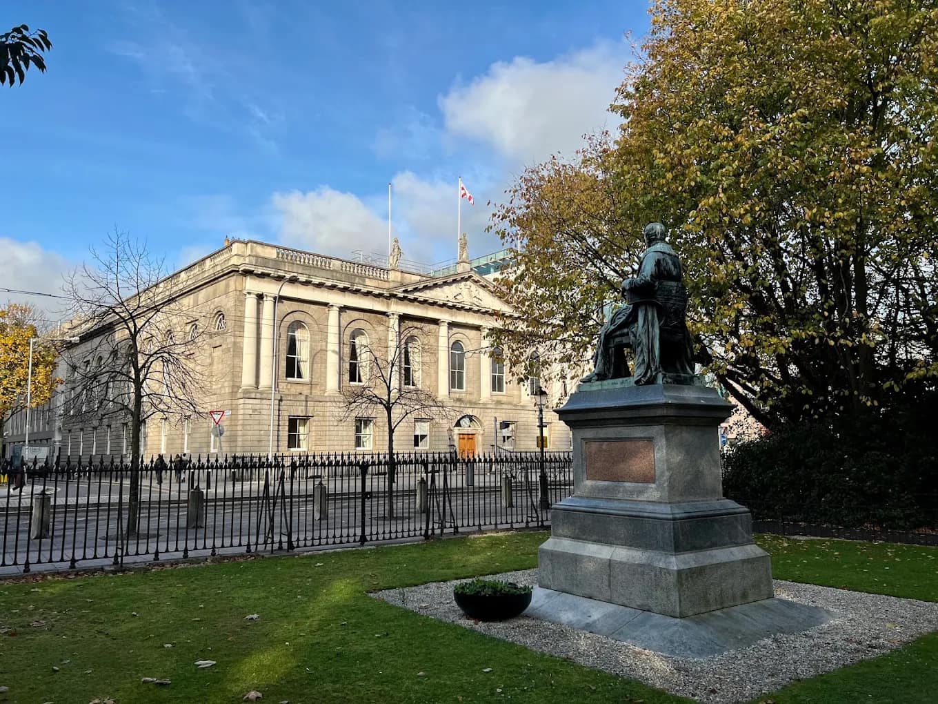 Historic granite building of the Royal College of Surgeons in Ireland with a commemorative statue