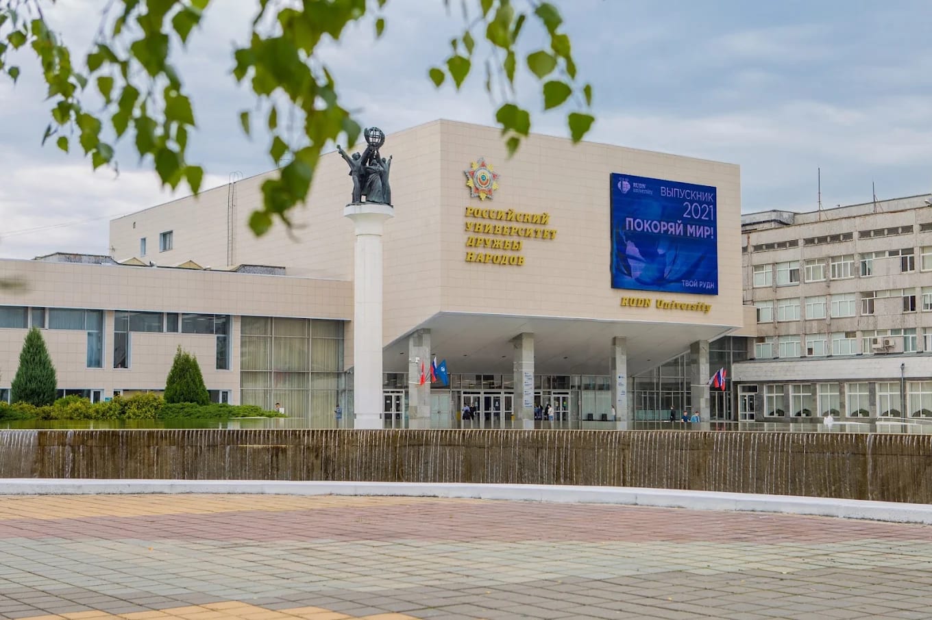 The main building of RUDN University in Moscow with the globe monument and Russian and English signage