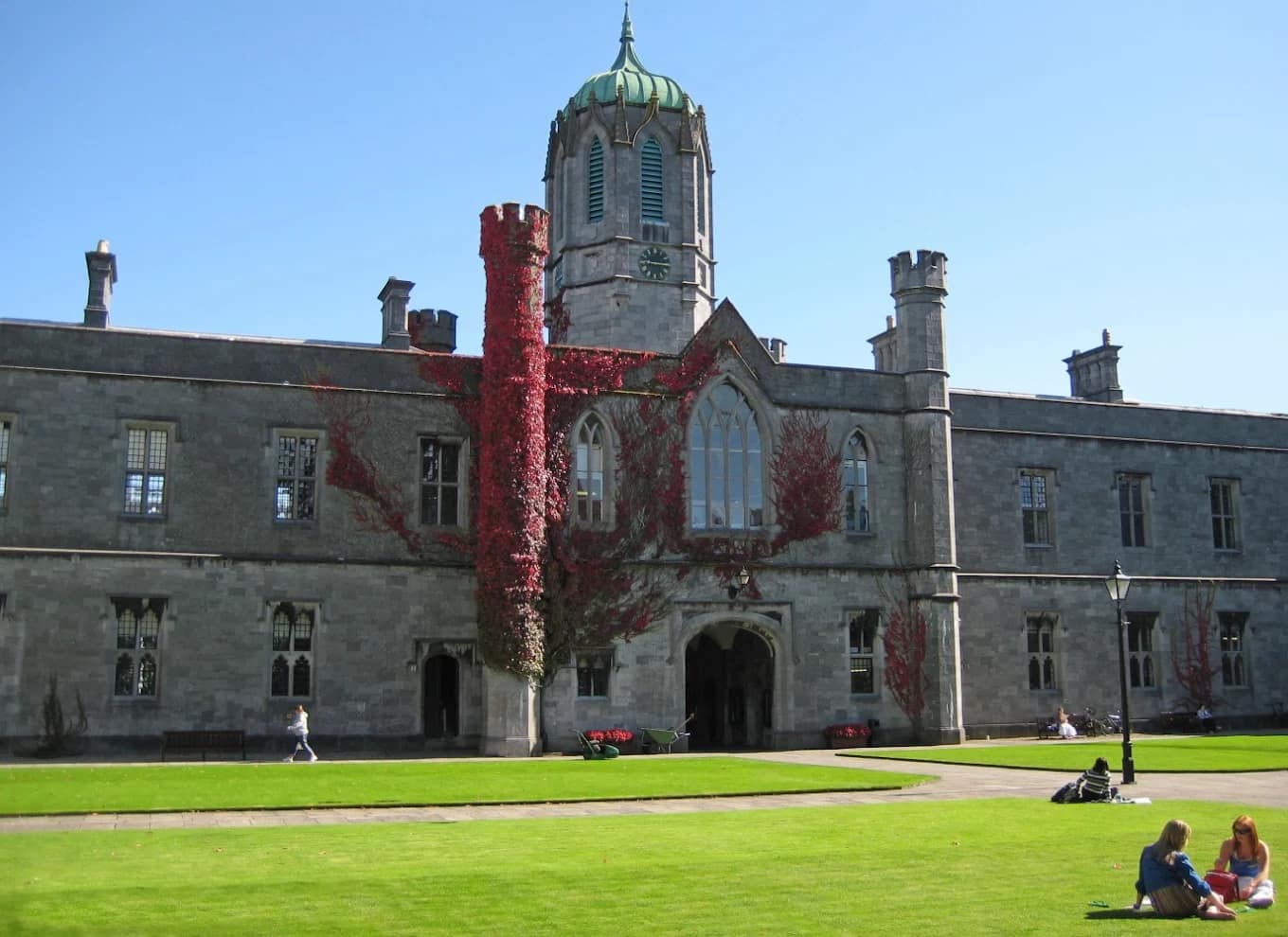 Students on the lawn in front of the ivy-clad Quadrangle building