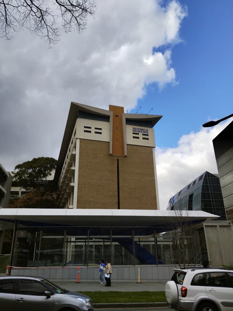 A University of Melbourne campus building displaying 'THE UNIVERSITY OF MELBOURNE' signage, Parkville, Melbourne