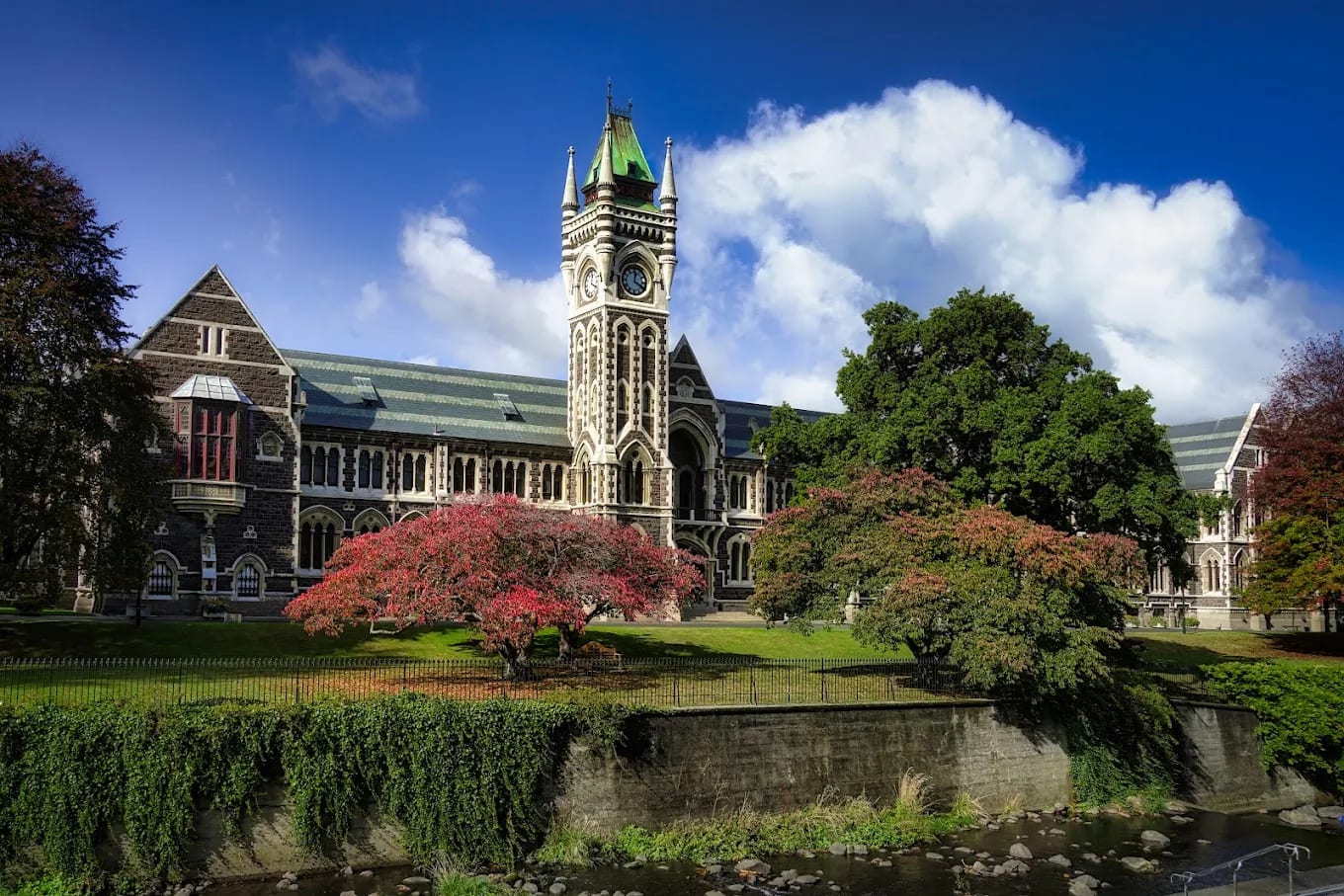 The University of Otago's Clocktower (Registry) building beside the Water of Leith in Dunedin, in autumn