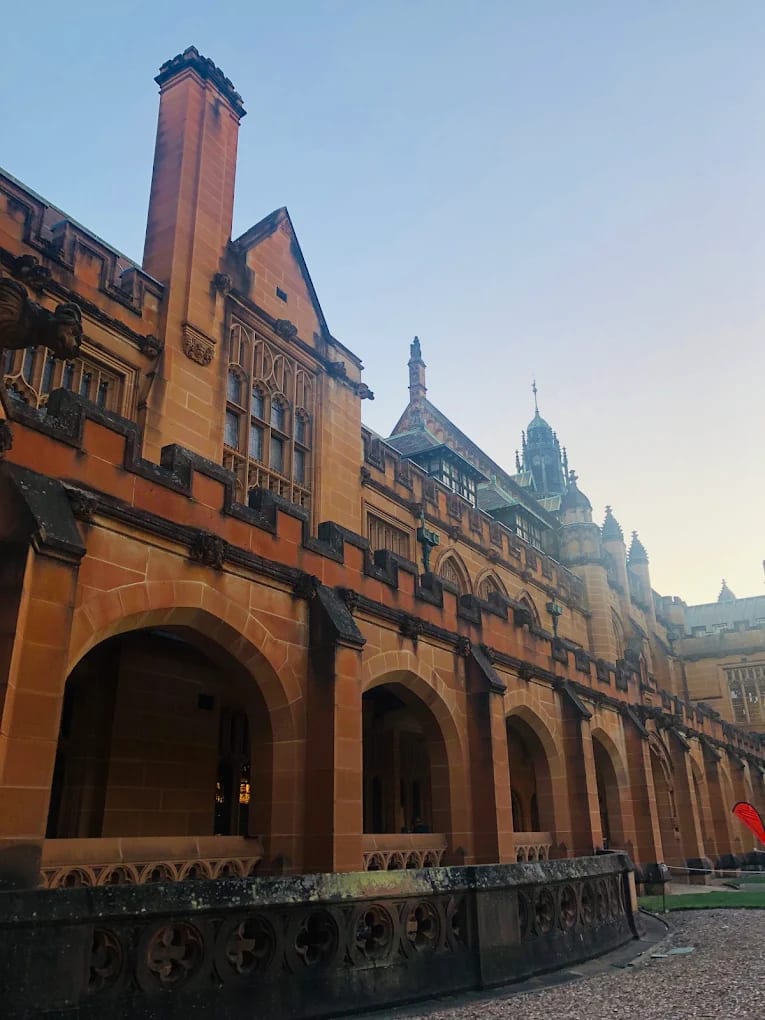 The sandstone Gothic cloisters and arches of the University of Sydney Quadrangle at dusk, Camperdown campus