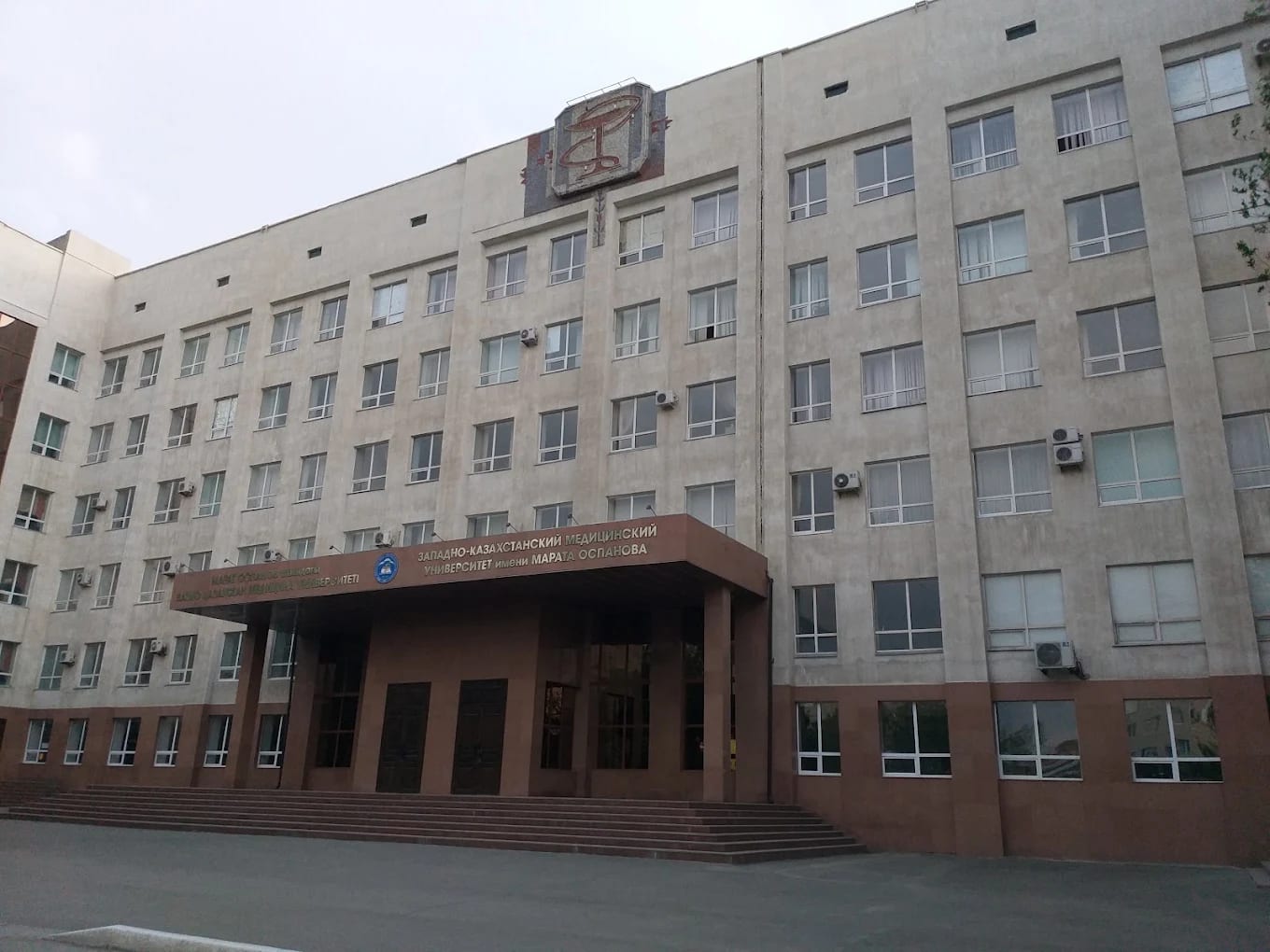 The main building of West Kazakhstan Marat Ospanov Medical University in Aktobe, with its Kazakh and Russian signage above the entrance