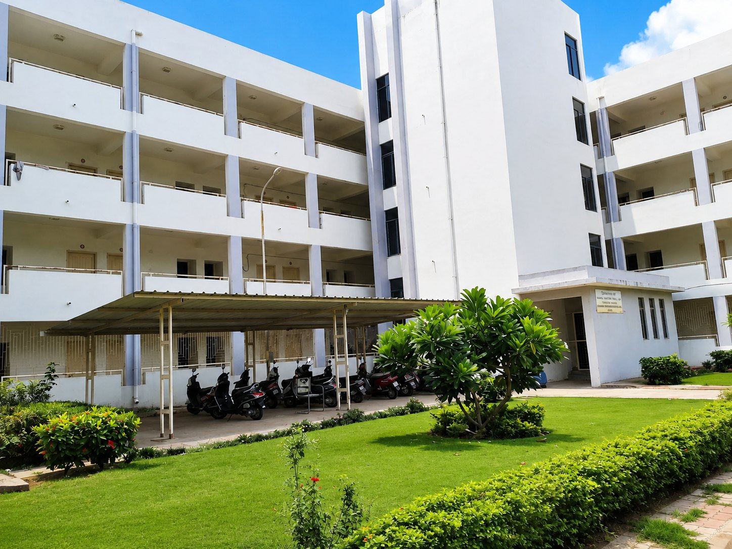 A multi-storey building with lawn at GMC Surat