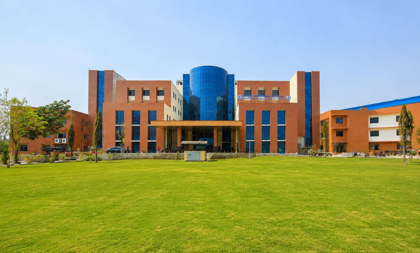 Wide lawn view of the red-brick and blue-glass main academic building of Government Medical College, Bettiah in Bihar