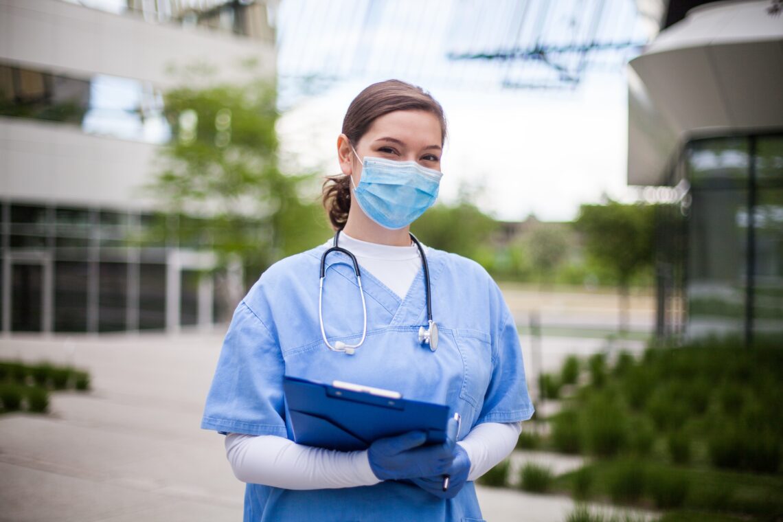 Female doctor standing in front of prestigious University Hospital, Pilsen in UK